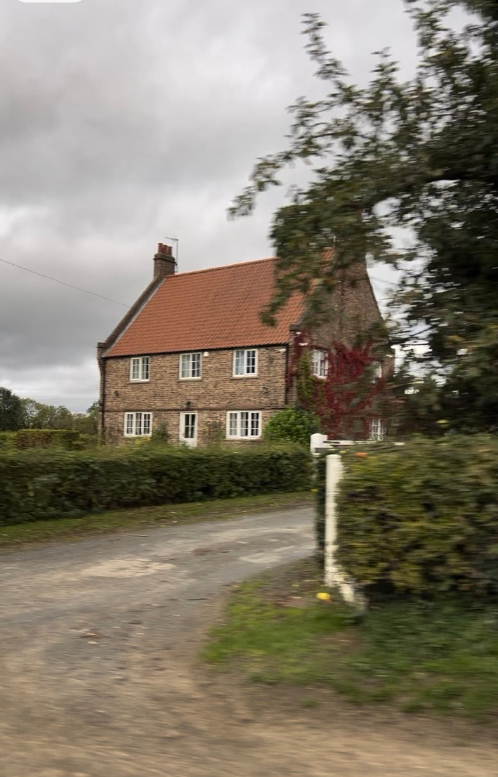 Stone English cottage with garden hedge red roof on the lane 