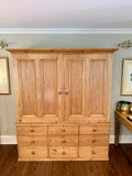An authentic English Victorian pine Housemaid's Cupboard featuring two interior shelves, nine hand-dovetailed drawers, original pine knobs, and its original working key. A timeless antique linen press sourced from England.