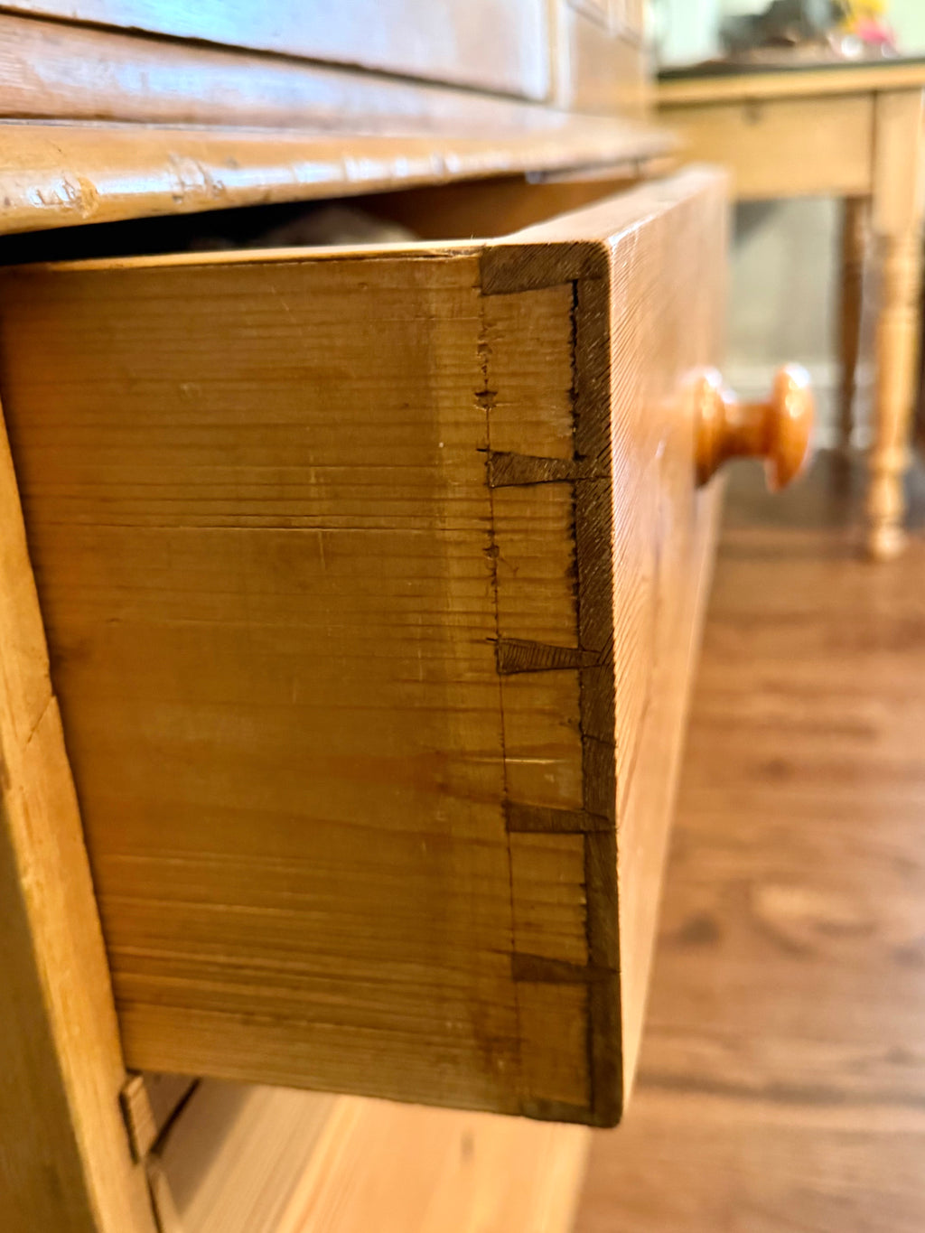 An authentic English Victorian pine Housemaid's Cupboard featuring two interior shelves, nine hand-dovetailed drawers, original pine knobs, and its original working key. A timeless antique linen press sourced from England.