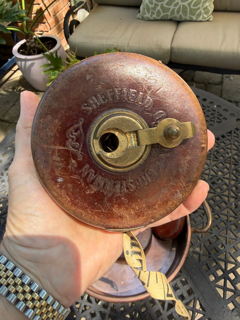 tape measure featuring brass hardware, woven cloth tape