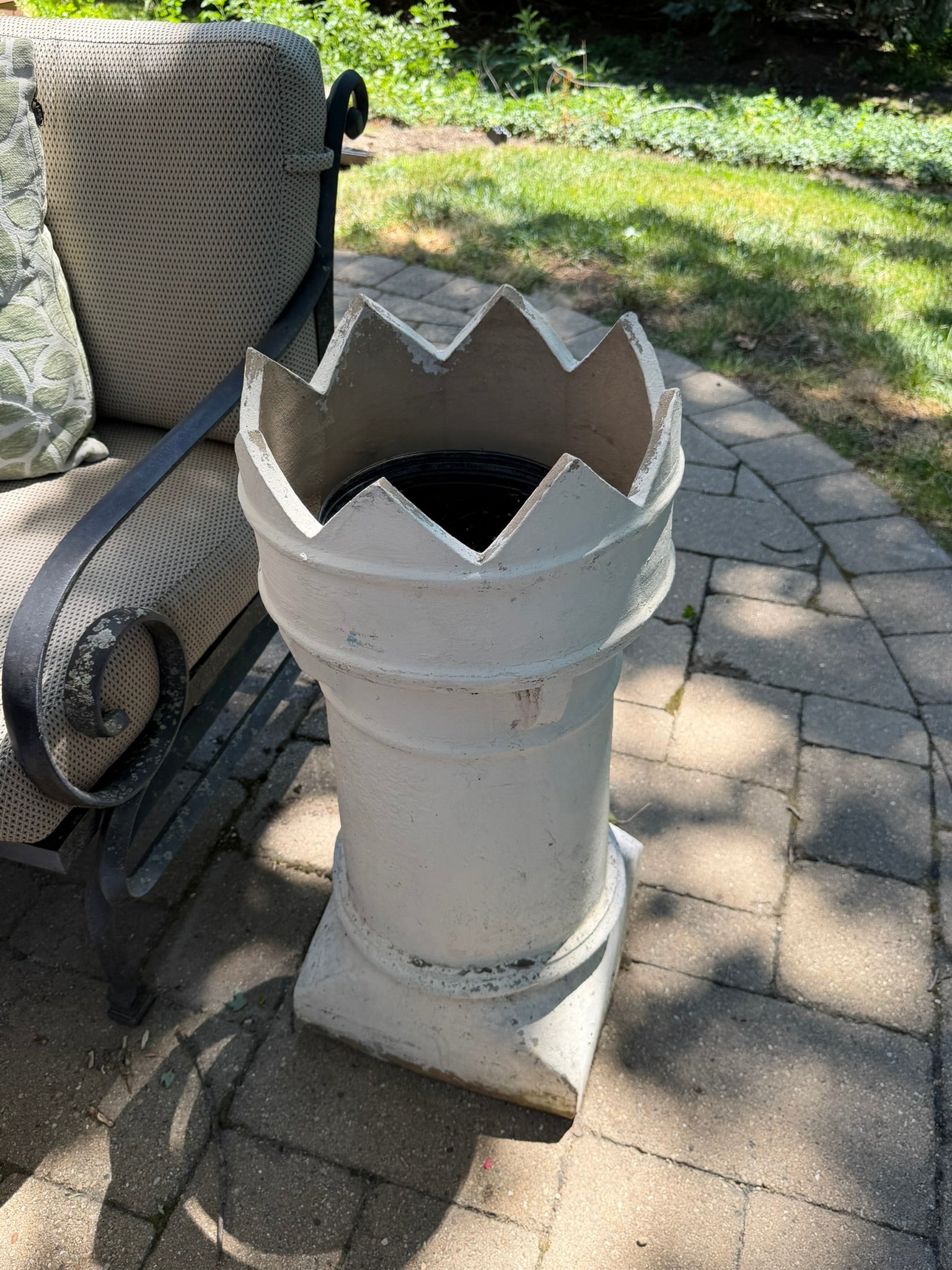 This is the top of a vintage English crown chimney pot that has been painted white 
