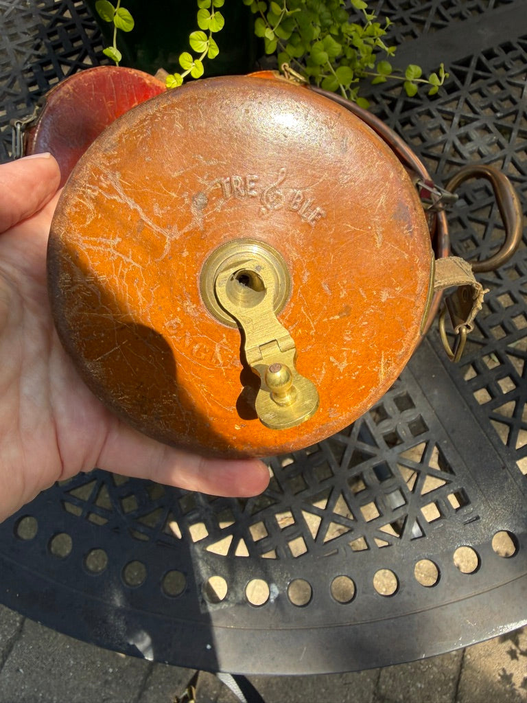 A vintage leather tape measure featuring brass hardware, woven cloth tape, and beautiful aged patina. A charming collectible for sewing rooms, libraries, and heritage-inspired interiors.