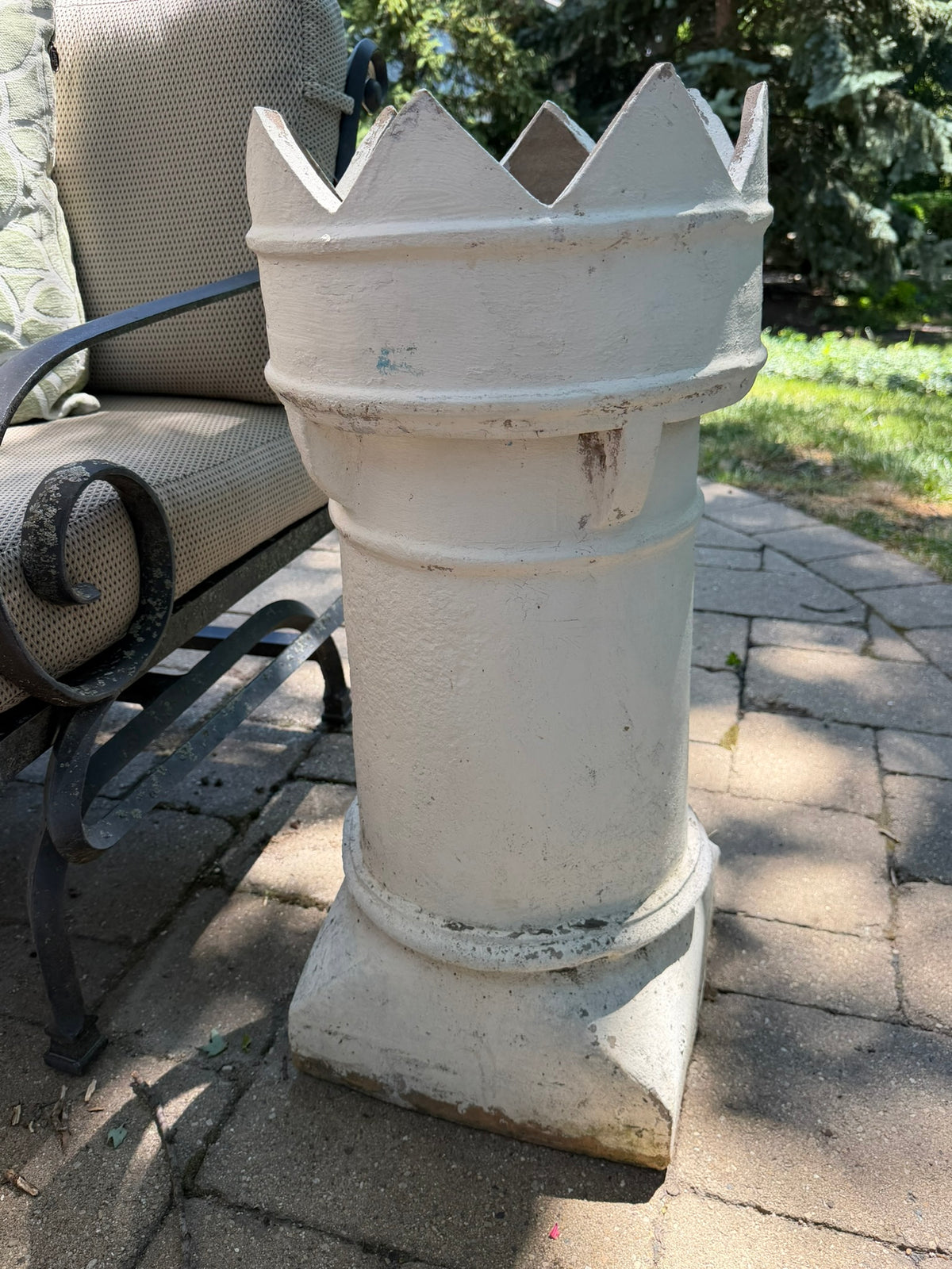 This is a vintage English crown chimney pot that has been painted white close up 