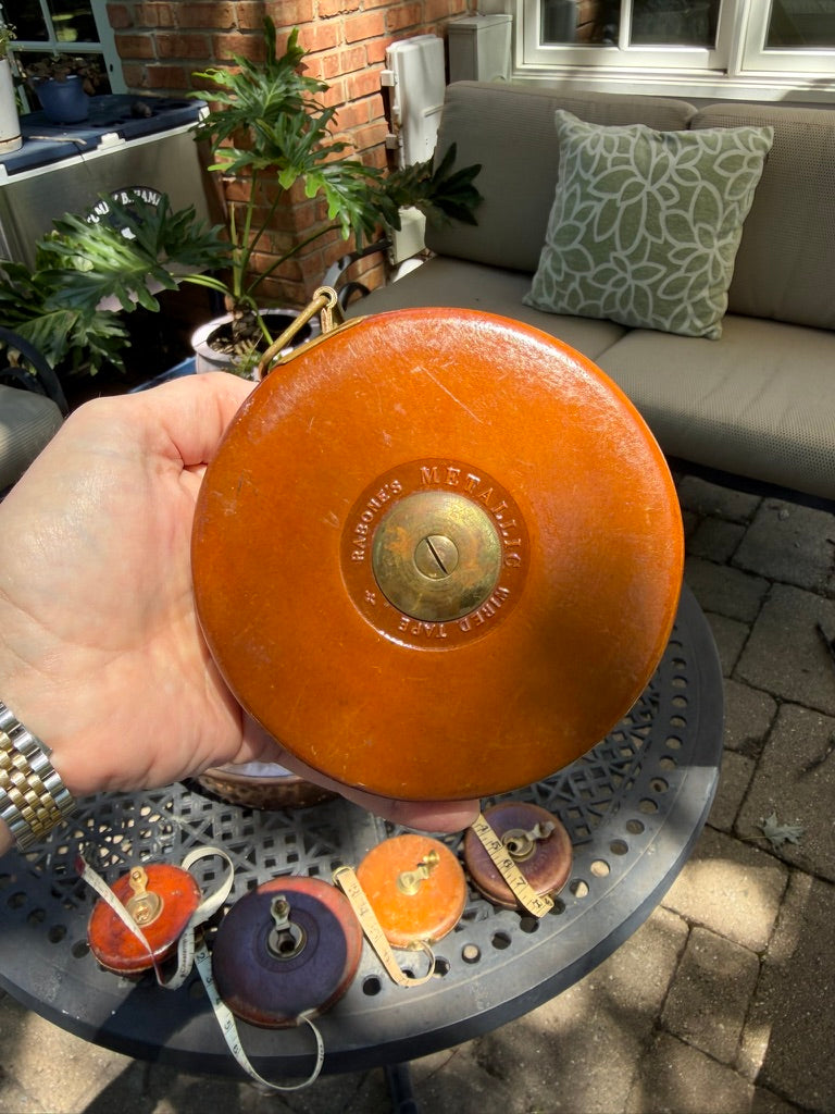 A beautifully crafted antique 66-foot leather measuring tape by John Rabone & Sons of Birmingham, England. Encased in richly aged leather with solid brass fittings and its original woven tape, this piece reflects the exceptional craftsmanship for which Rabone became renowned.